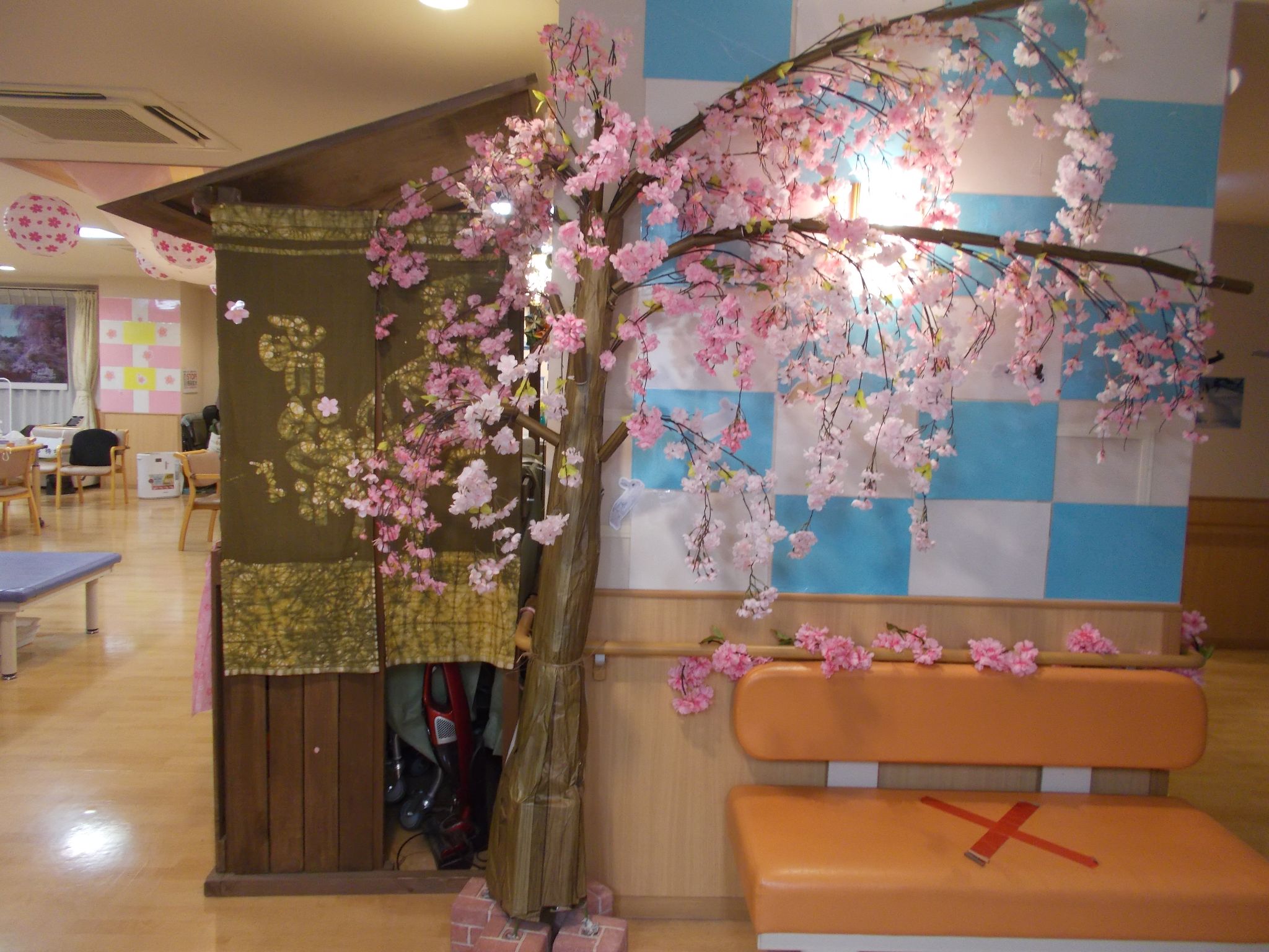 満開の桜の造花と和風の装飾で彩られた「リハビリの家 東浦和」のフロア